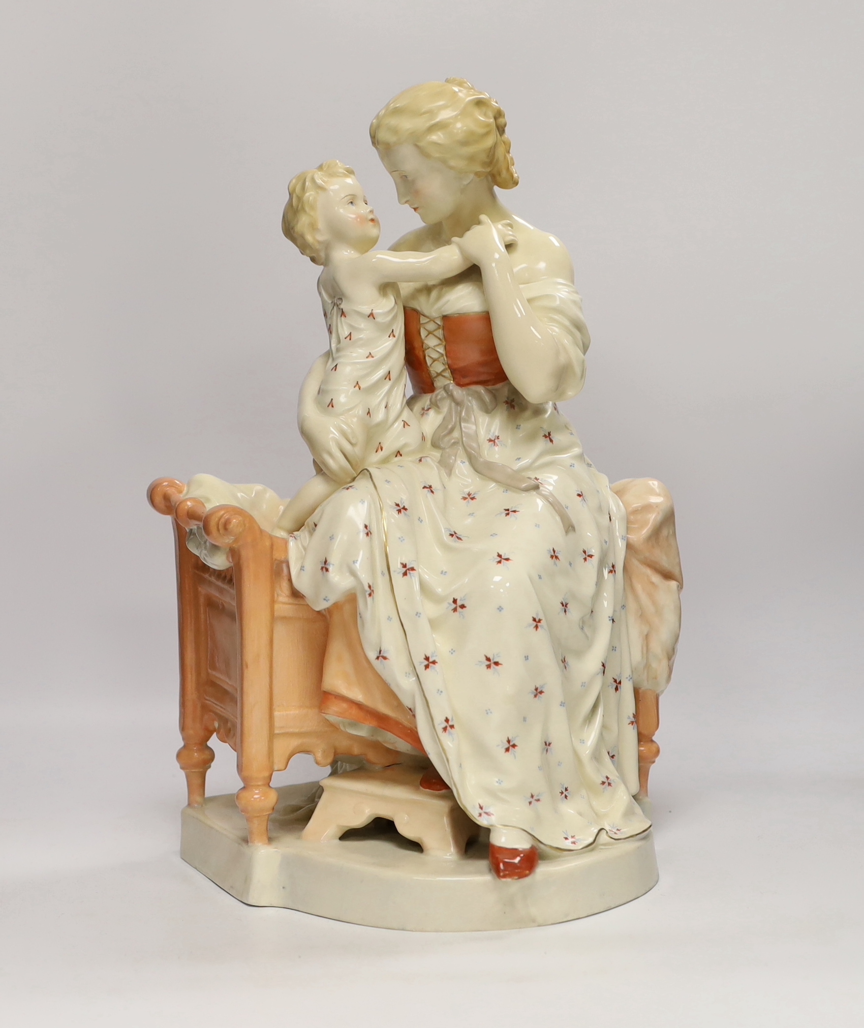 A large French porcelain seated ‘mother and child’ group and a pair of figural candlesticks, figure group 39cm high